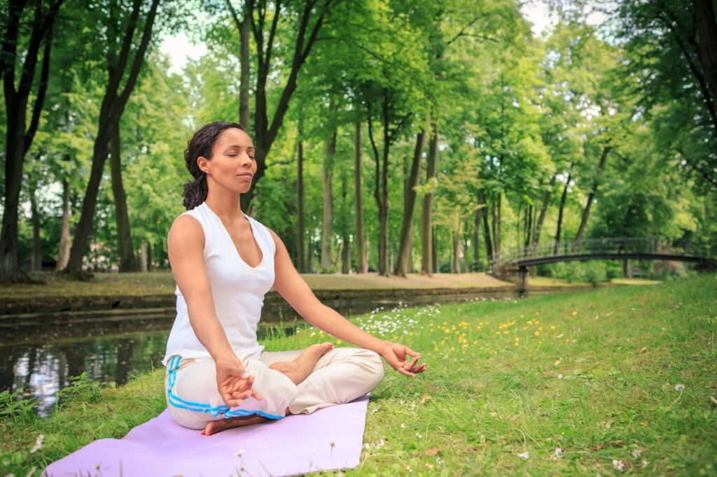 Germany, Woman exercising yoga in a park, Meditation