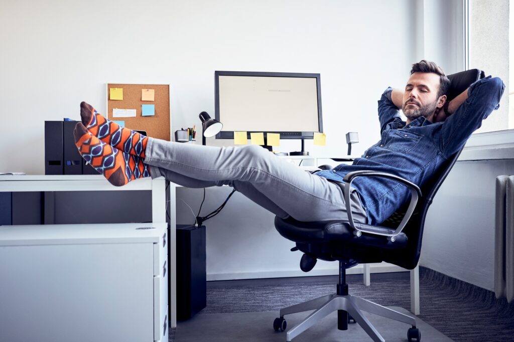 Man sitting at desk in office having a power nap