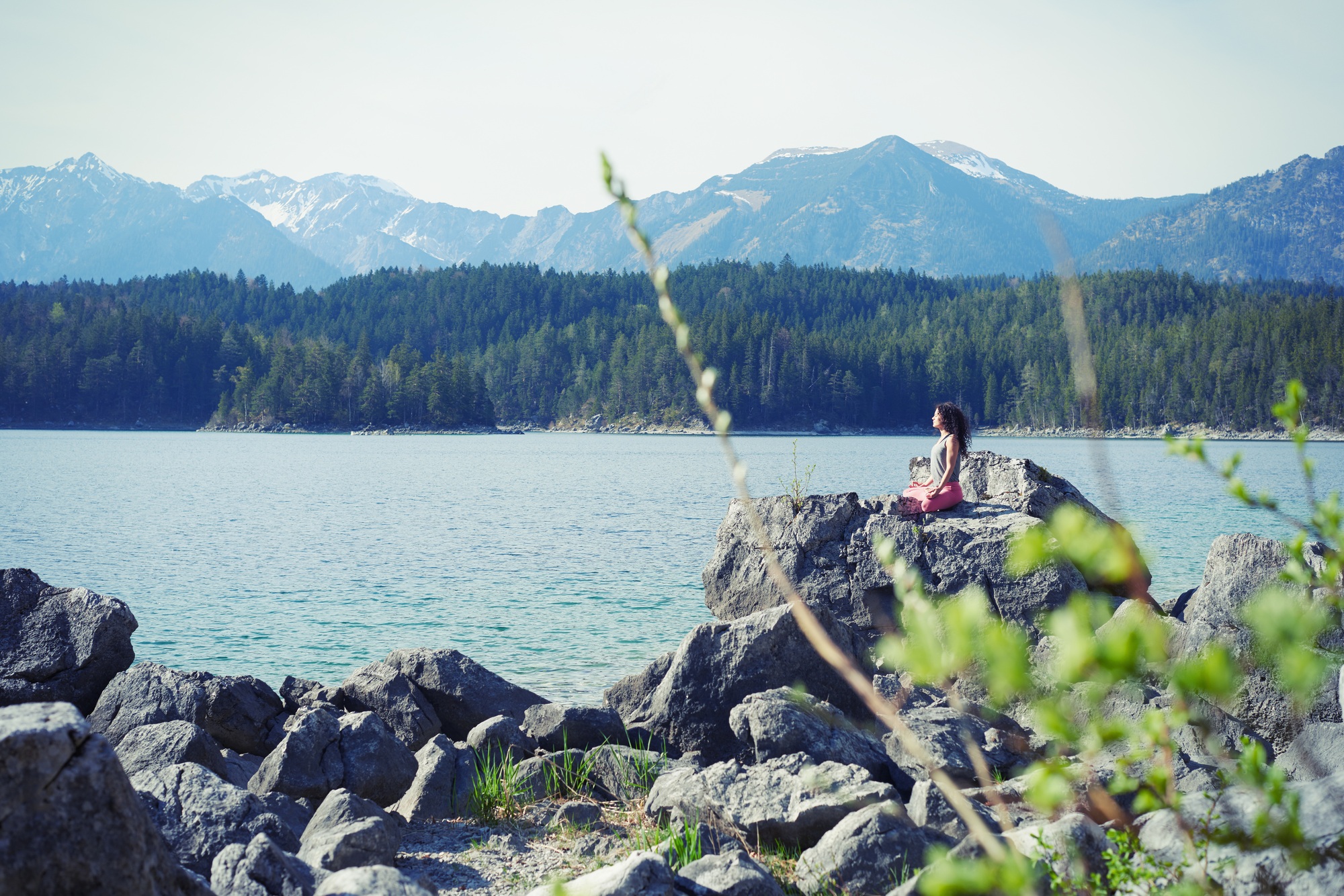 Mid adult woman, sitting on rock, in yoga position