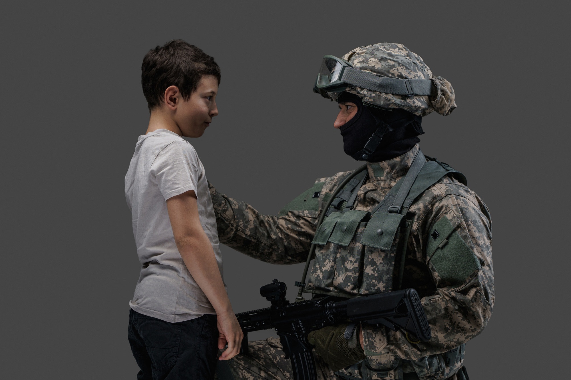 Special force army man with rifle and young kid
